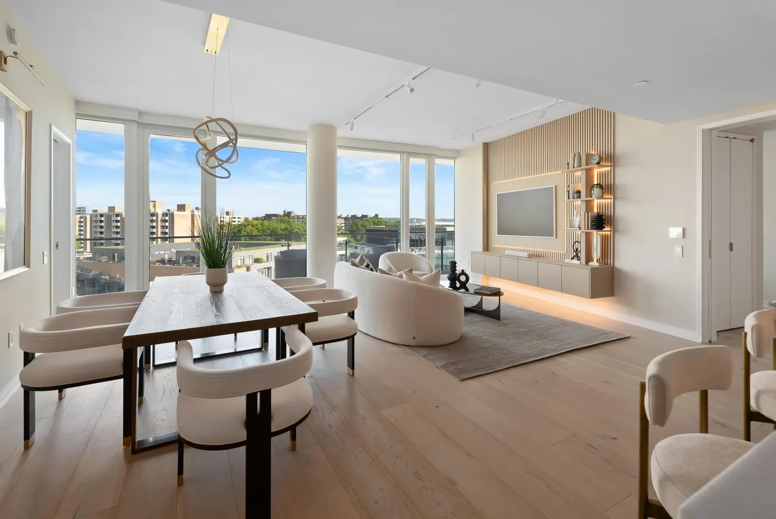 Living room with a slatted oak media wall, white armchairs and a round coffee table